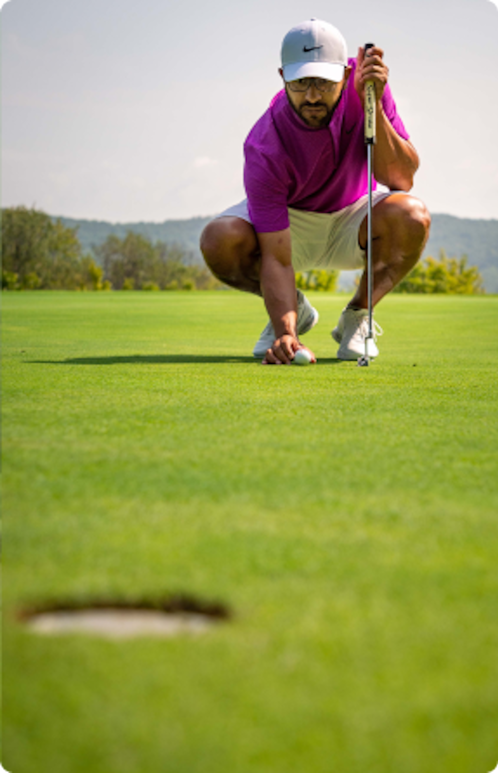 A golfer lines up his putt. 