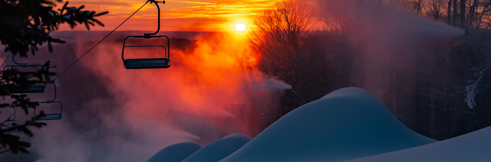 The morning sunrise on Morning Star with snow guns making piles of snow.