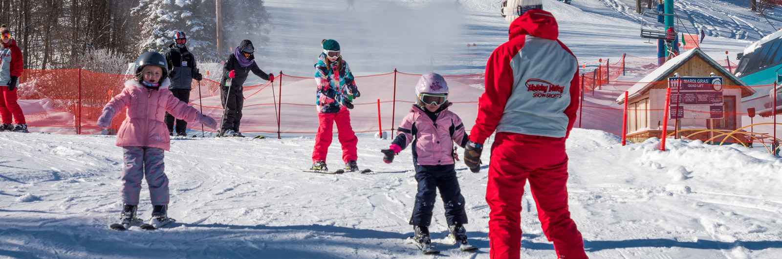 Children skiing down beginner slope during lesson