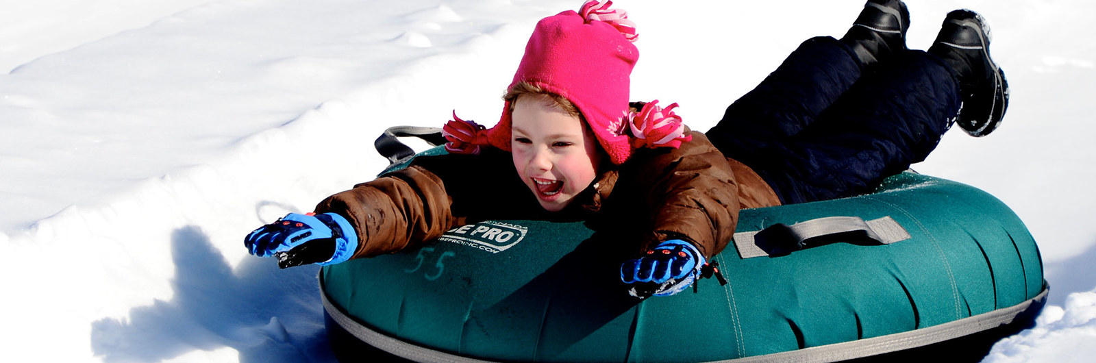 Child enjoying ride on snow tube