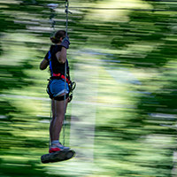 A young woman riding a swing at Sky High