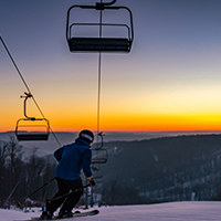 A skier makes a turn with a magnificent sunrise in the background.