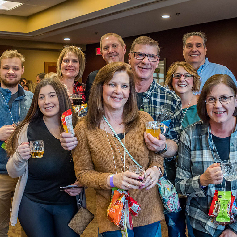 A group of nine people pose together for a photo during the Beer and Wine Festival.
