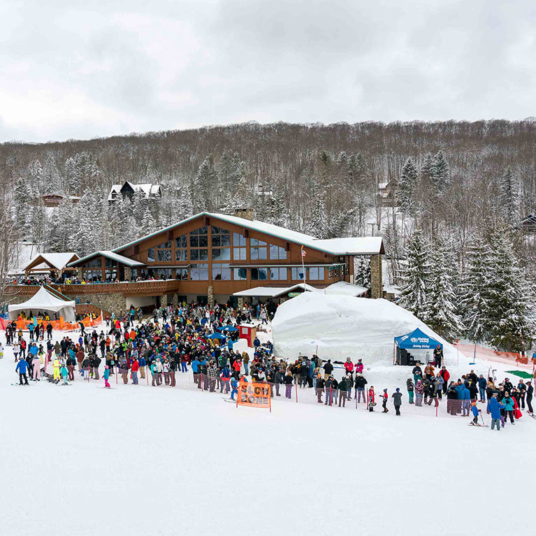 A large crowd of people gather around the Ice Bar during the annual Winter Carnival weekend.