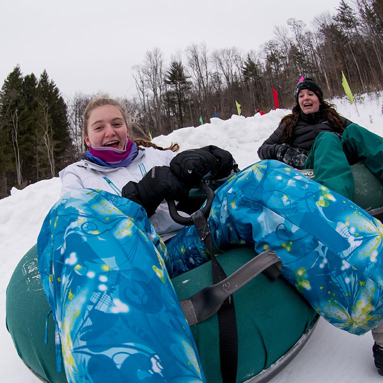 Girl snow tubing down the hill